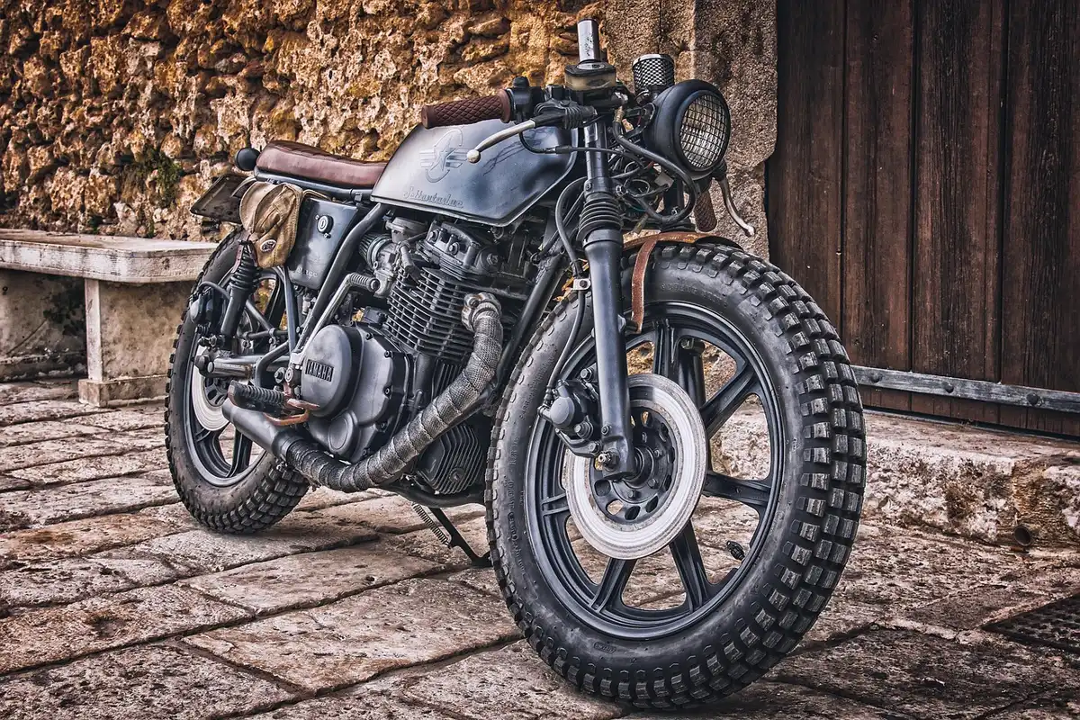 Atelier en plein jour avec cadre de moto ancien et bloc-moteur posé sur une table