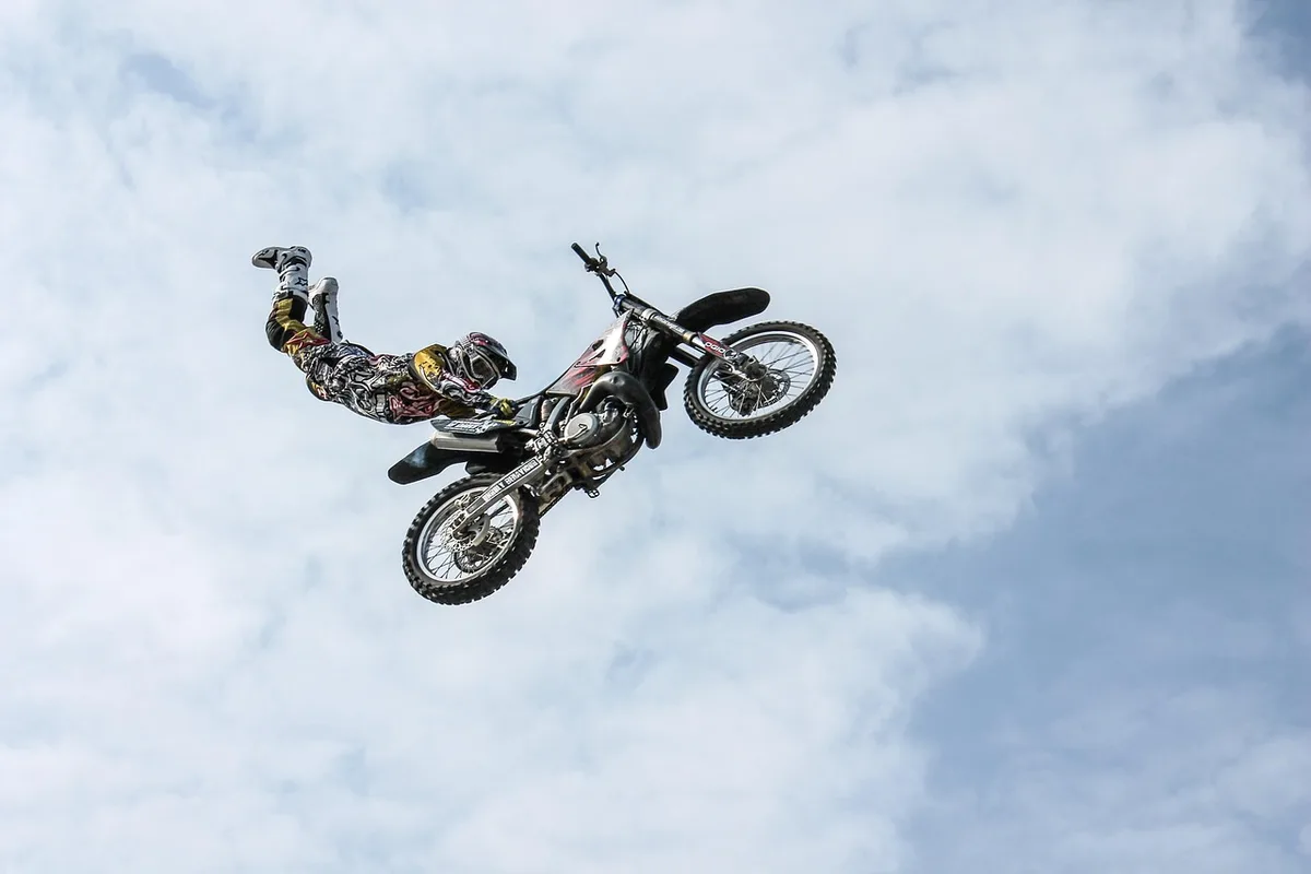 Technicien révisant une fourche et un amortisseur de moto en atelier