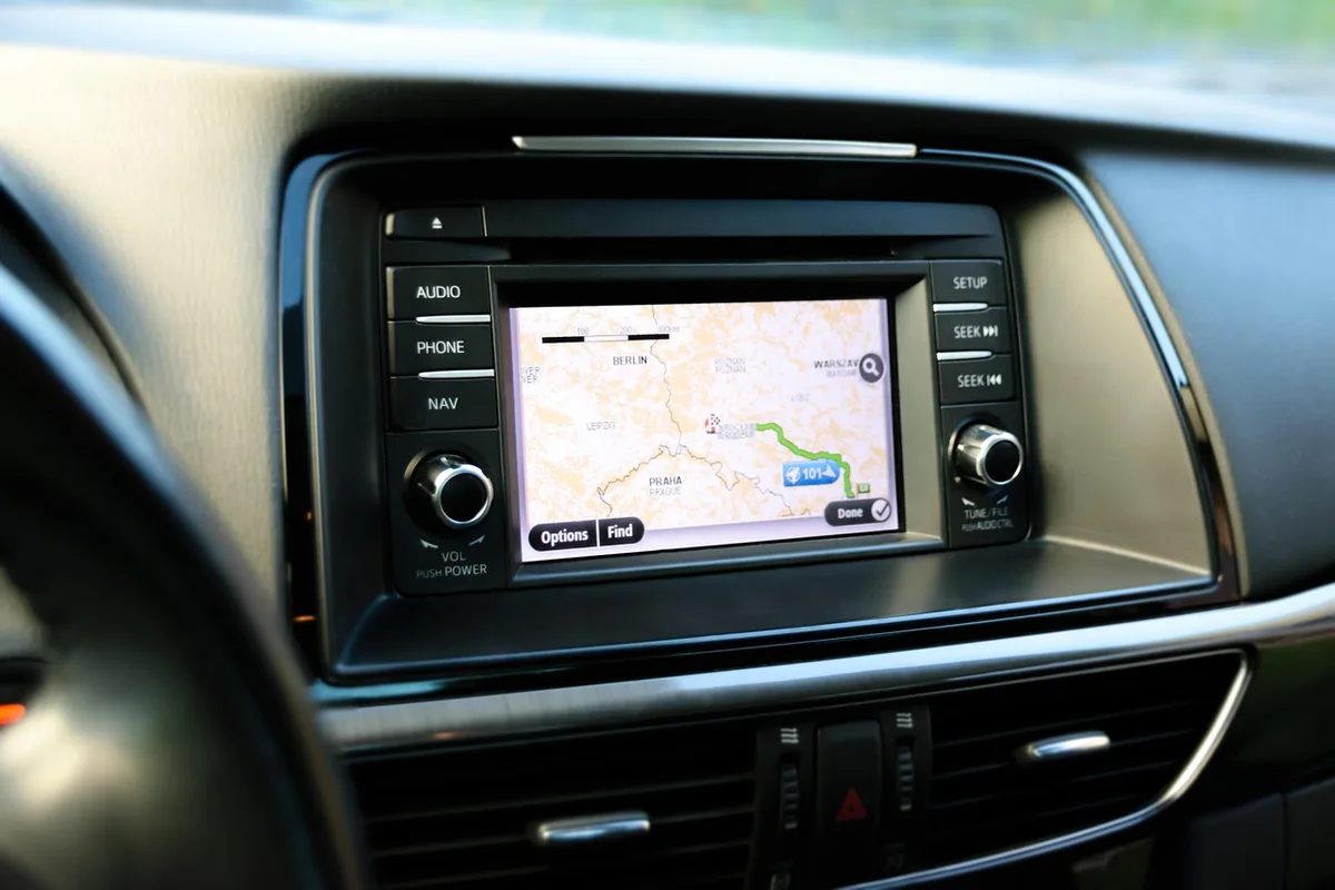 Conducteur consultant un GPS et préparant sa trajectoire avant un rond‑point