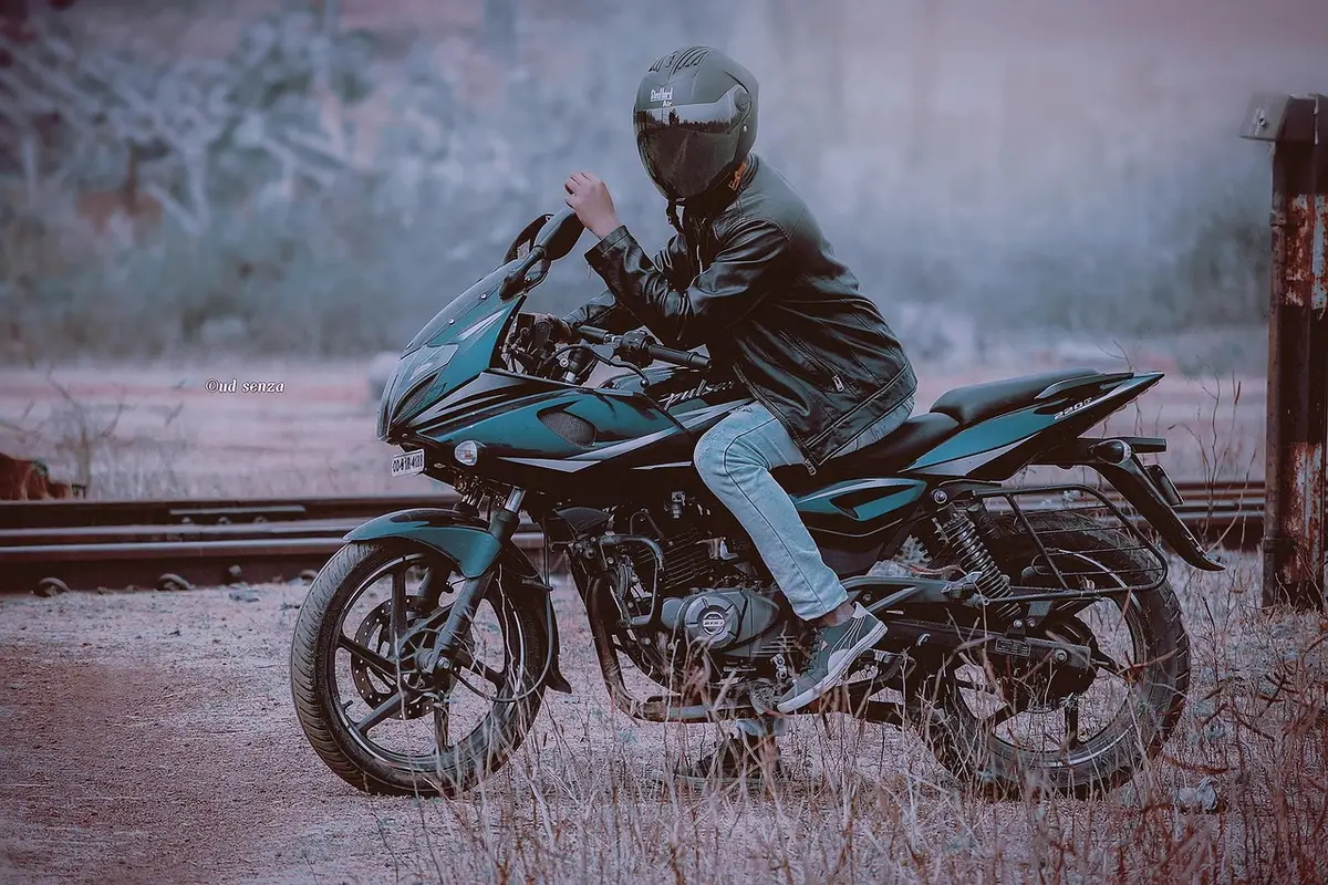 Casque posé sur une petite moto devant un garage en plein jour, document d'assurance en arrière-plan flou