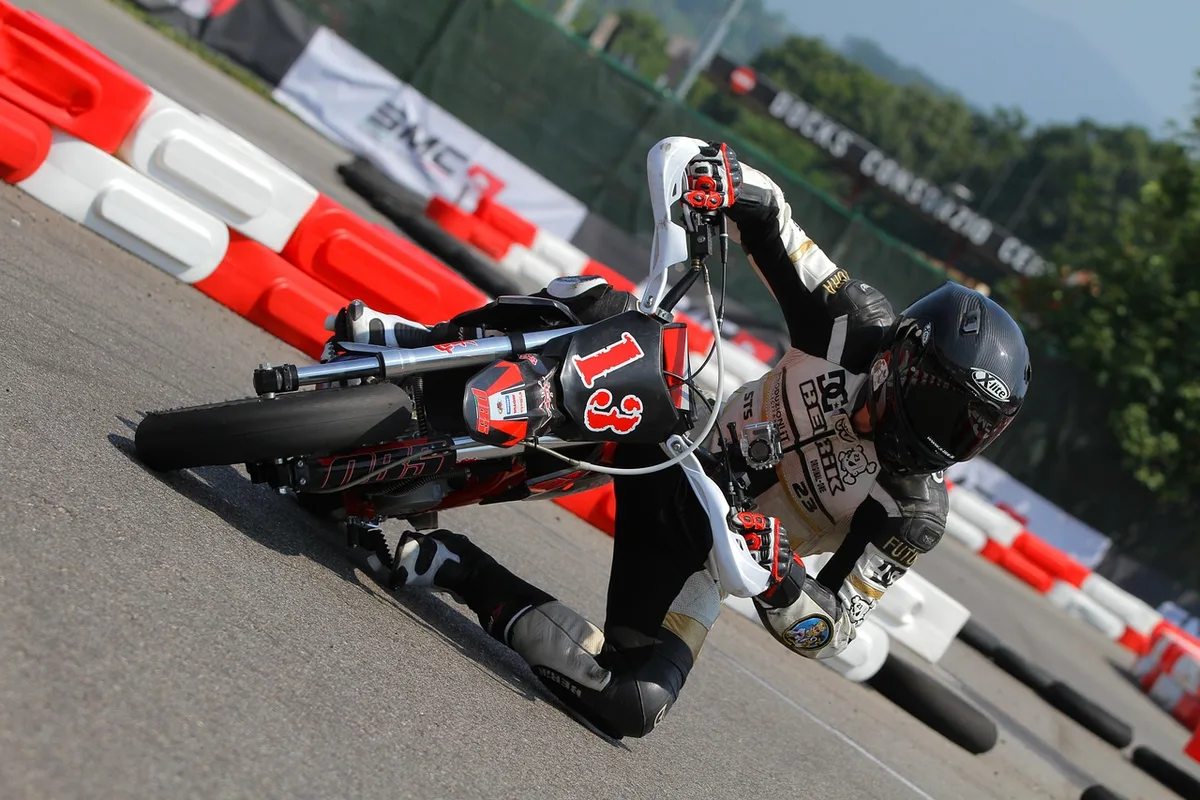 Box de stand de course en journée avec outils et casques, moto floue en arrière-plan